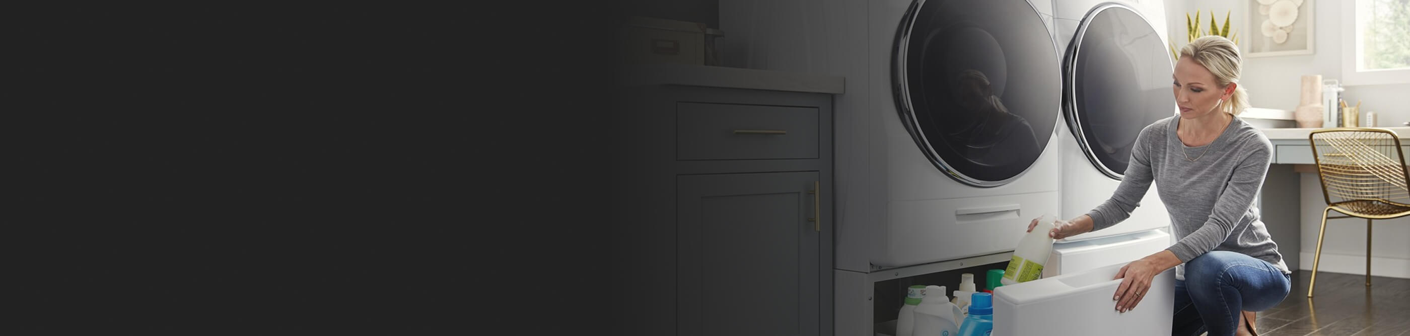 Person placing cleaner in pedestal storage beneath laundry unit