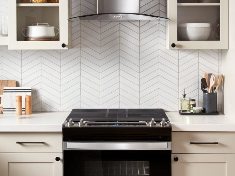 A black range and range hood in a modern kitchen A black range and range hood in a modern kitchen