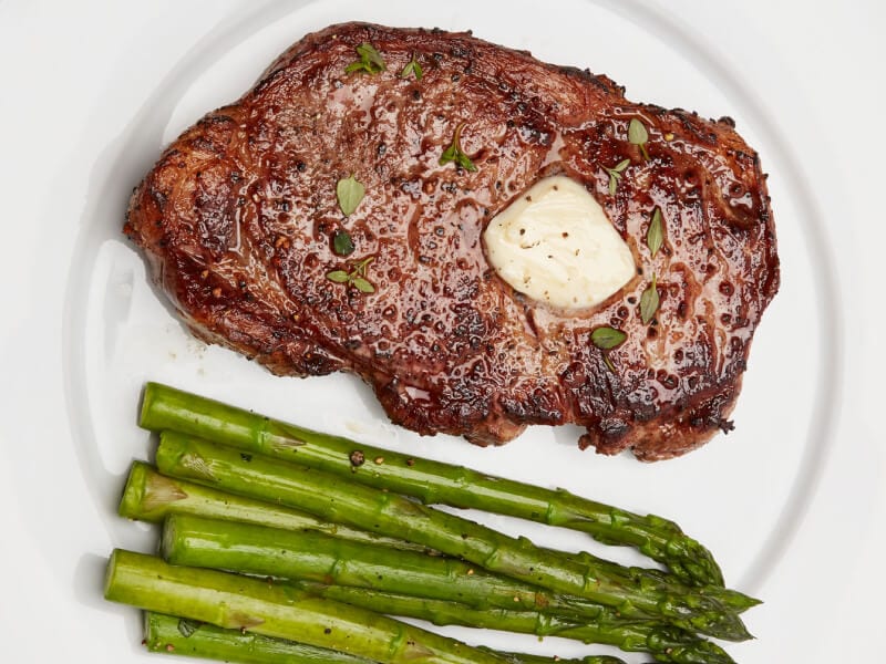 A seared steak with butter and roasted asparagus A seared steak with butter and roasted asparagus