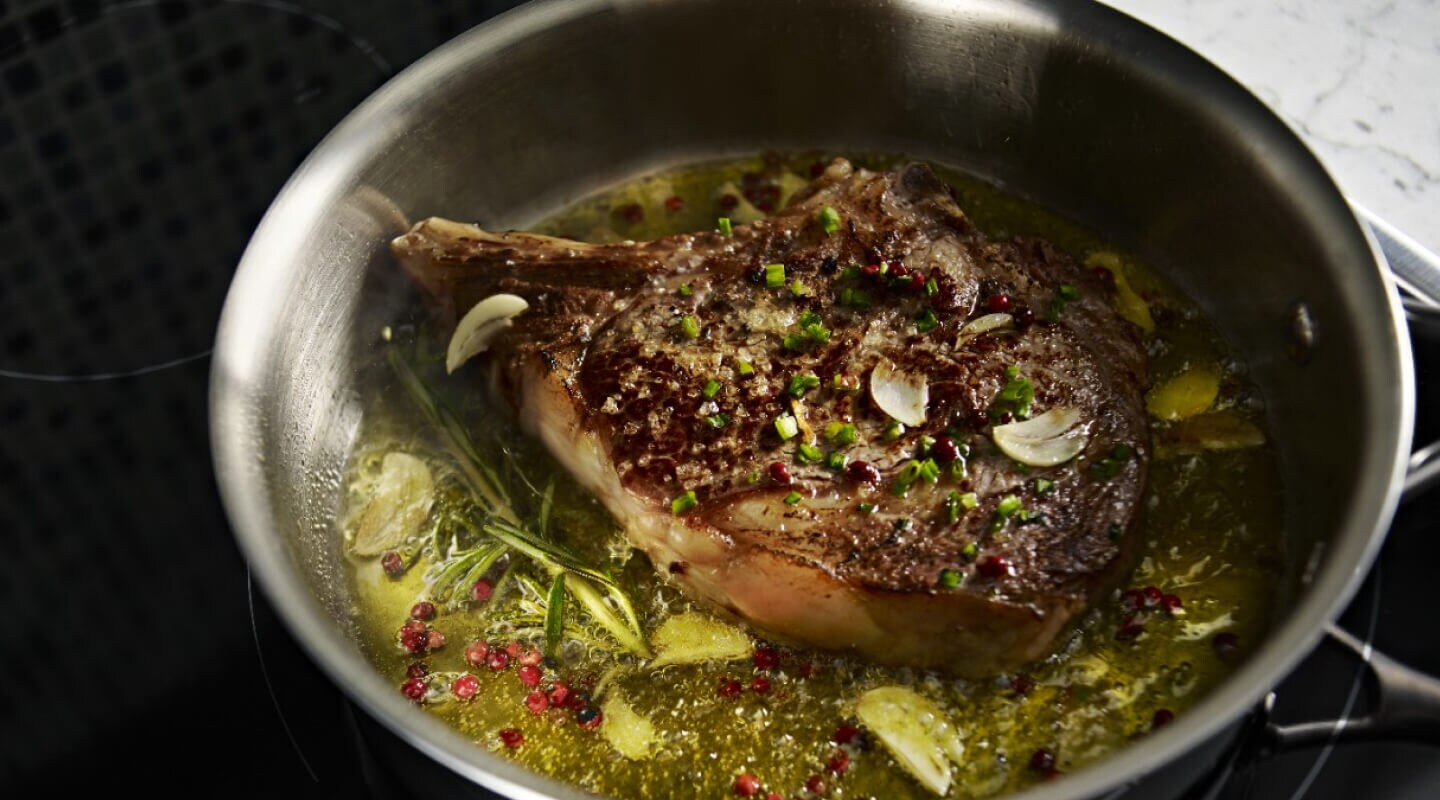 A large piece of meat, simmering in a pot A large piece of meat, simmering in a pot