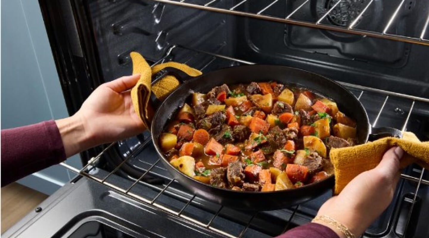 Pot of stew coming out of an oven