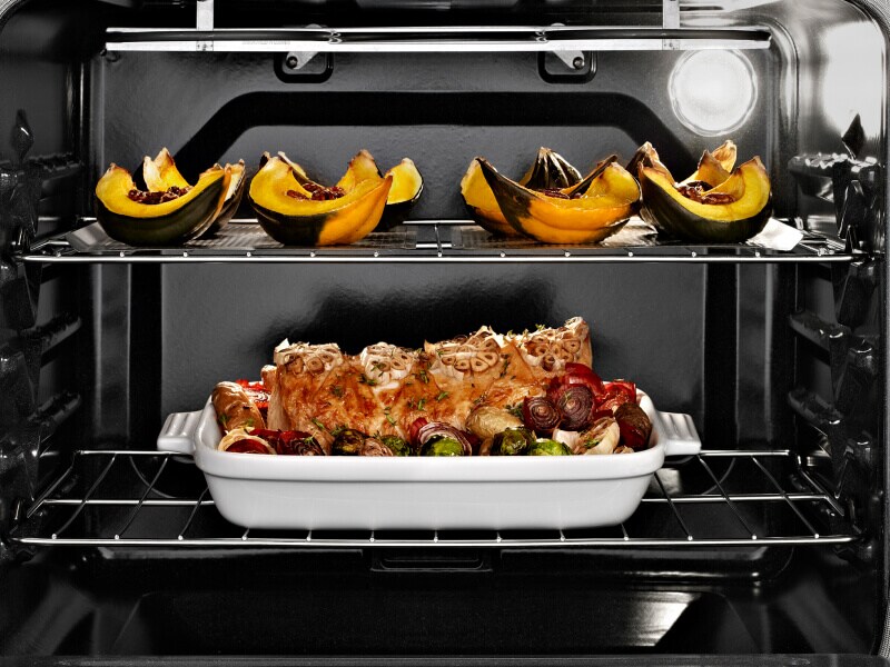 Oven open with cooked food on both racks Oven open with cooked food on both racks