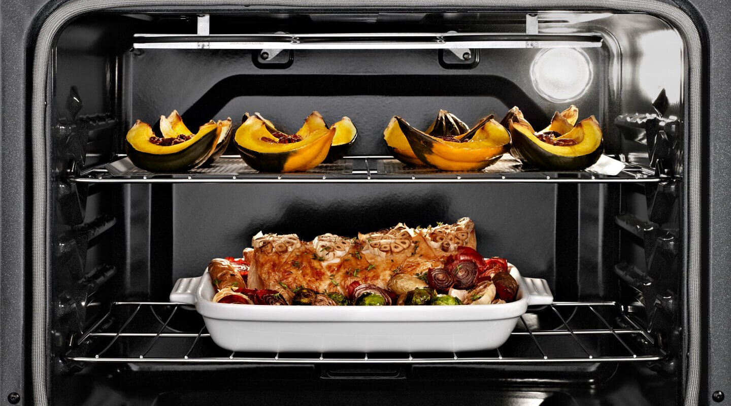 Oven open with cooked food on both racks Oven open with cooked food on both racks