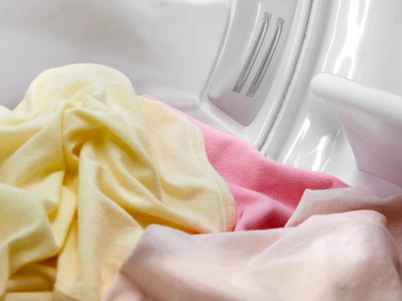 Yellow and pink garments in a dryer Yellow and pink garments in a dryer