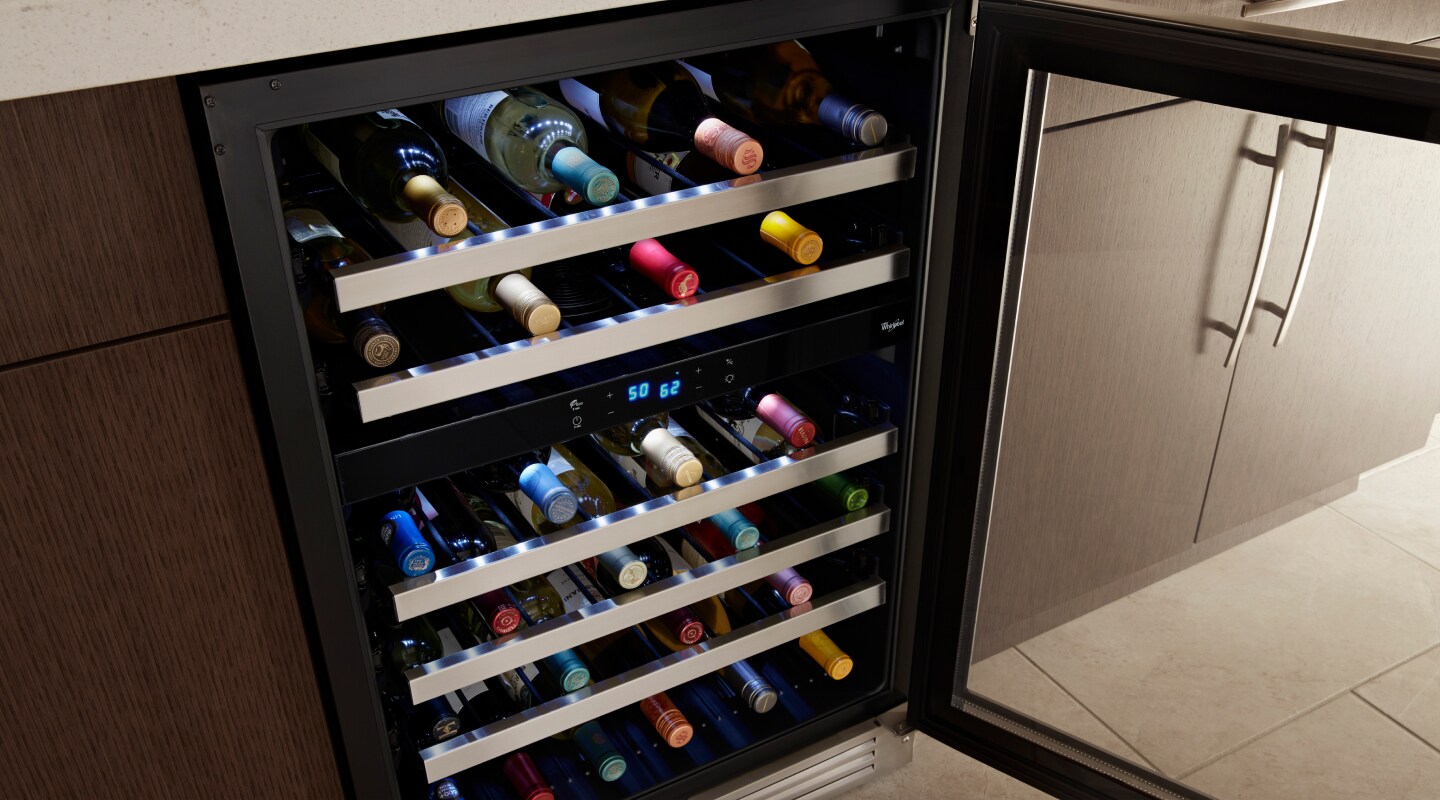Wine bottles stored on the various levels of a wine fridge Wine bottles stored on the various levels of a wine fridge