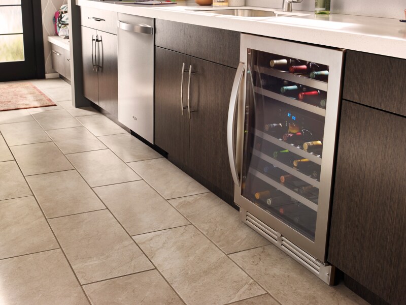 A stainless steel wine fridge in a modern kitchen with different appliances A stainless steel wine fridge in a modern kitchen with different appliances