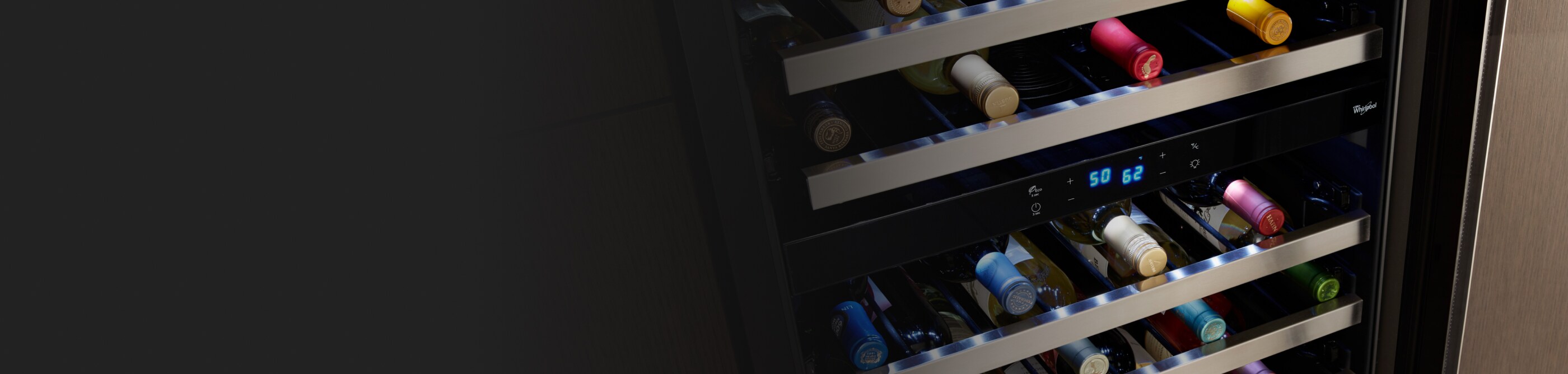 Wine bottles stored on the various levels of a wine fridge