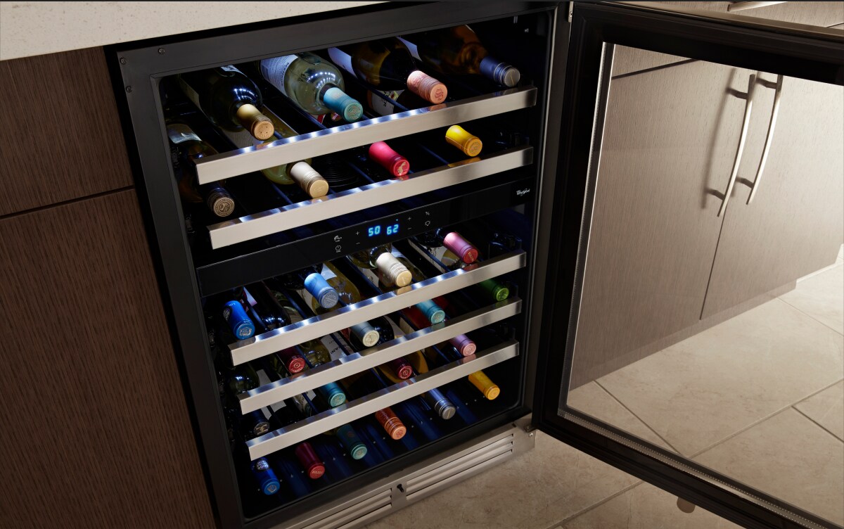 Wine bottles stored on the various levels of a wine fridge Wine bottles stored on the various levels of a wine fridge