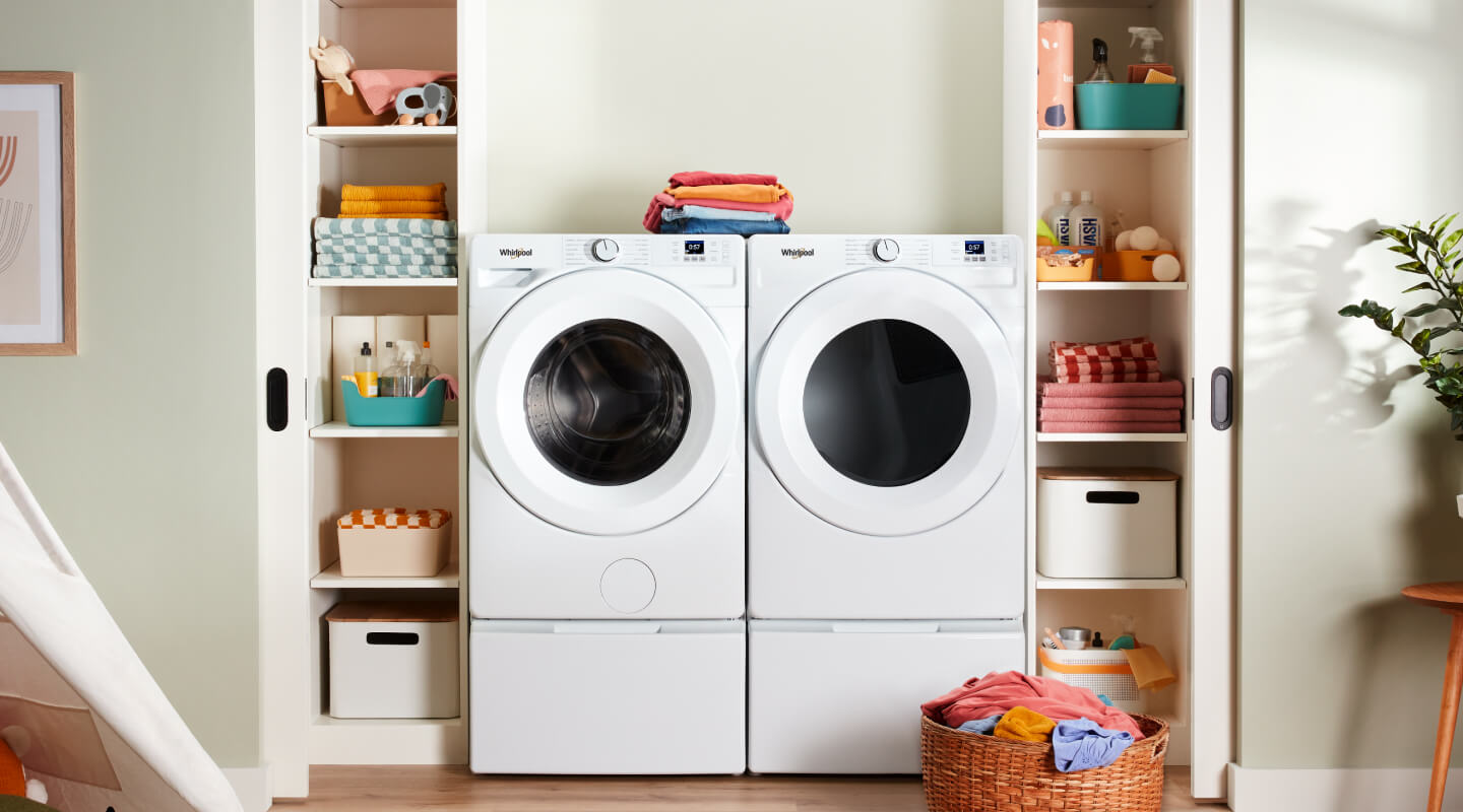 A bright laundry area with a white, front load washer and dryer set
