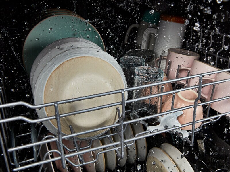 A closeup of dishes being cleaned in a dishwasher A closeup of dishes being cleaned in a dishwasher