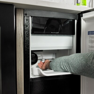 Person removing ice from an icemaker