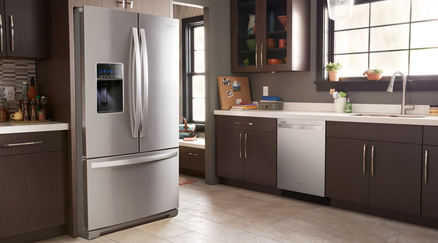 A kitchen with a stainless steel French door refrigerator