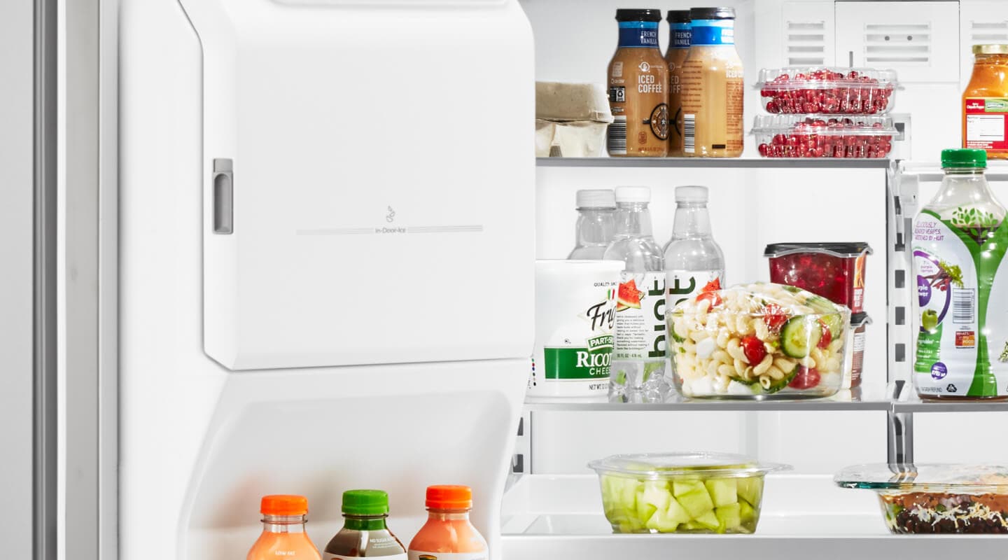 An open fridge door, showing various food products on the shelves An open fridge door, showing various food products on the shelves