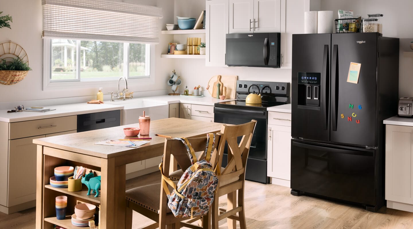 A kitchen with a black French door refrigerator
