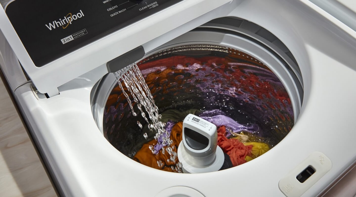 A closeup of water streaming into a Whirlpool® washer tub