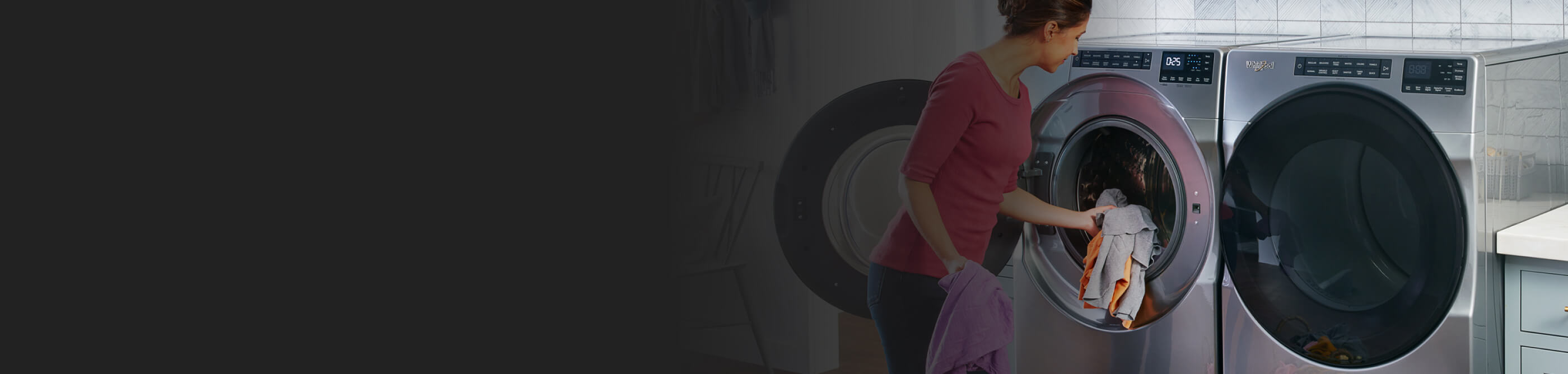 Person loading clothes into a front load Whirlpool brand washer