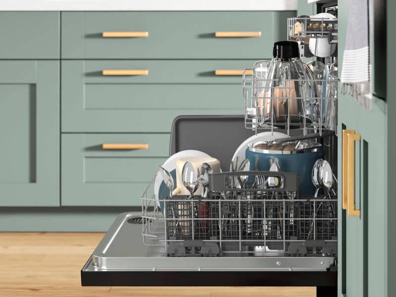 Side view of open dishwasher full of dishes with racks slightly extended Side view of open dishwasher full of dishes with racks slightly extended