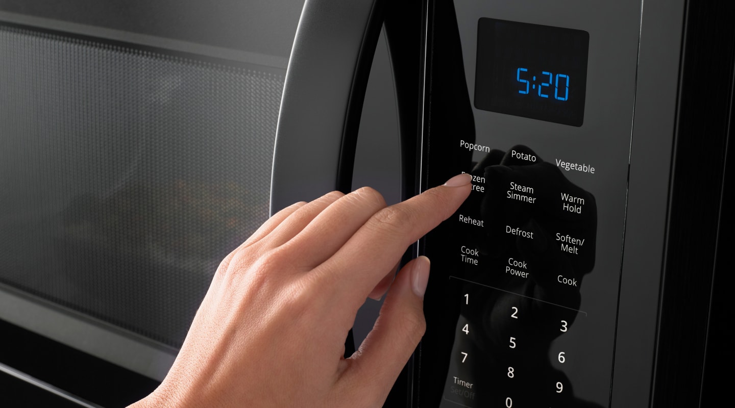 Hand pressing a microwave display Hand pressing a microwave display