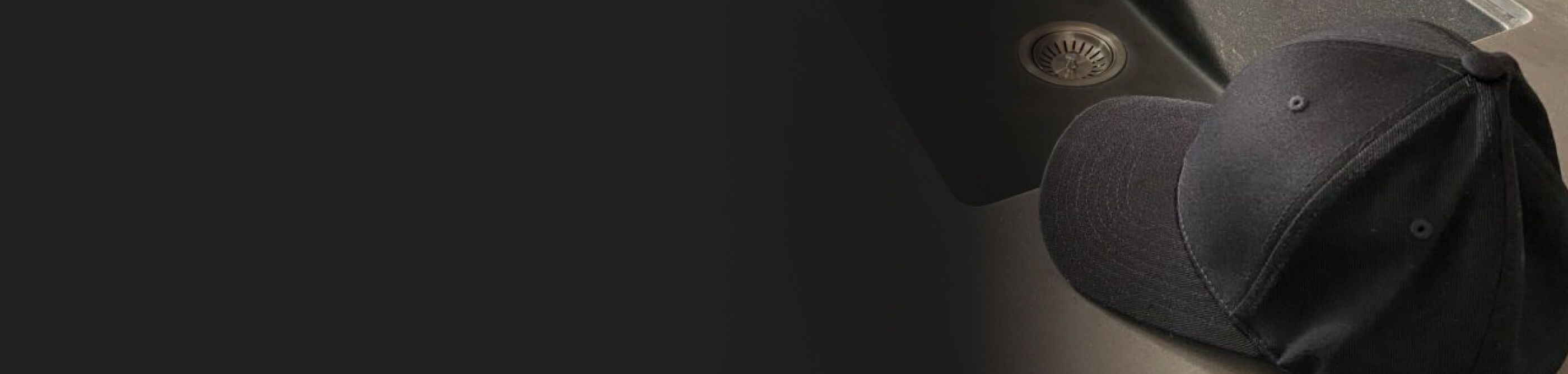 A black cloth baseball cap on a countertop