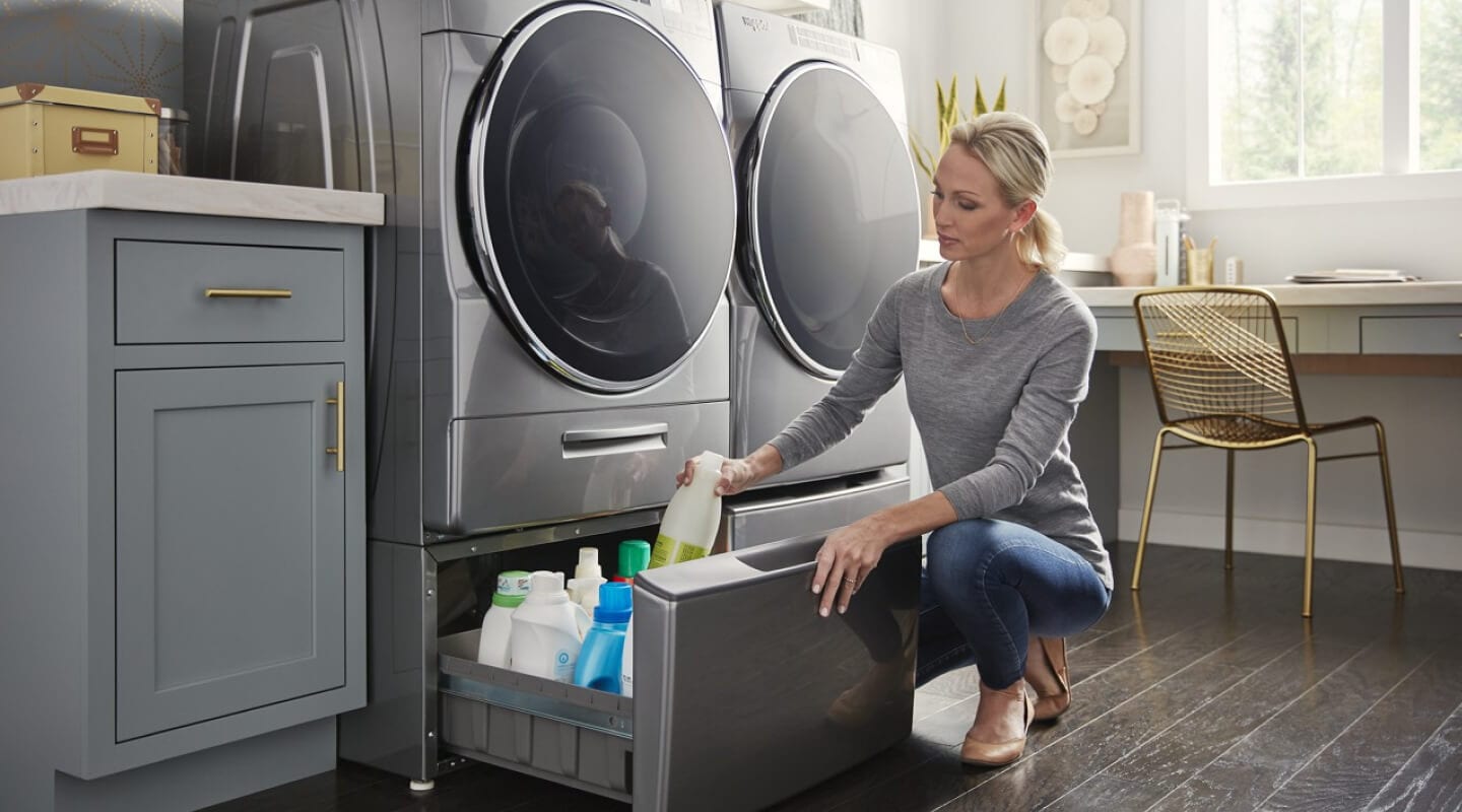 Person getting supplies from laundry pedestal drawer Person getting supplies from laundry pedestal drawer