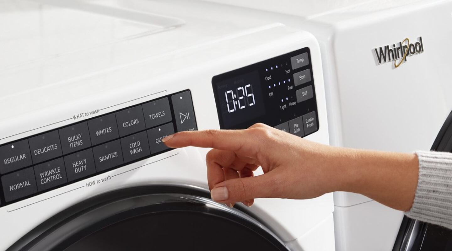 Person selecting settings on a washer control panel Person selecting settings on a washer control panel