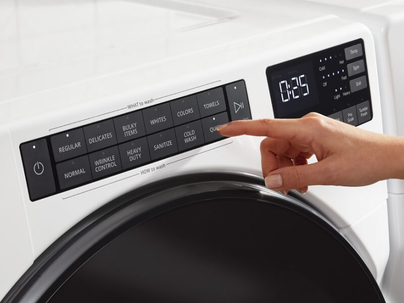 Person selecting settings on a washer control panel Person selecting settings on a washer control panel