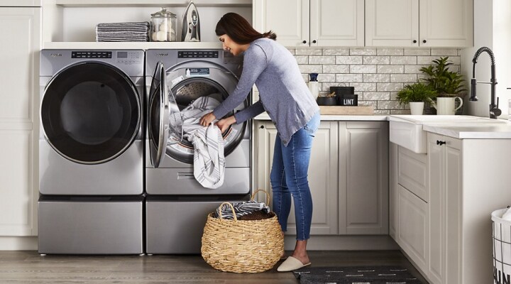 Person loading clothes into a Whirlpool® Front Load Washer