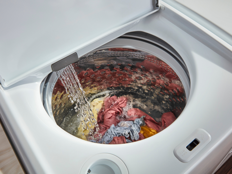 Water pouring into a full top-loading washer