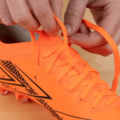 Person untying orange cleats