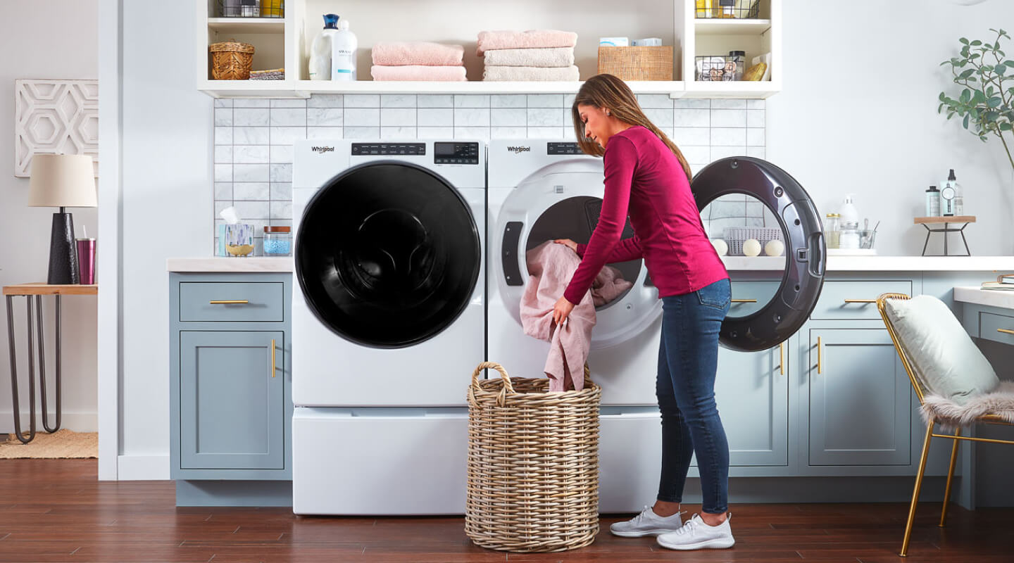 Person putting clothes in Whirlpool® washer Person putting clothes in Whirlpool® washer