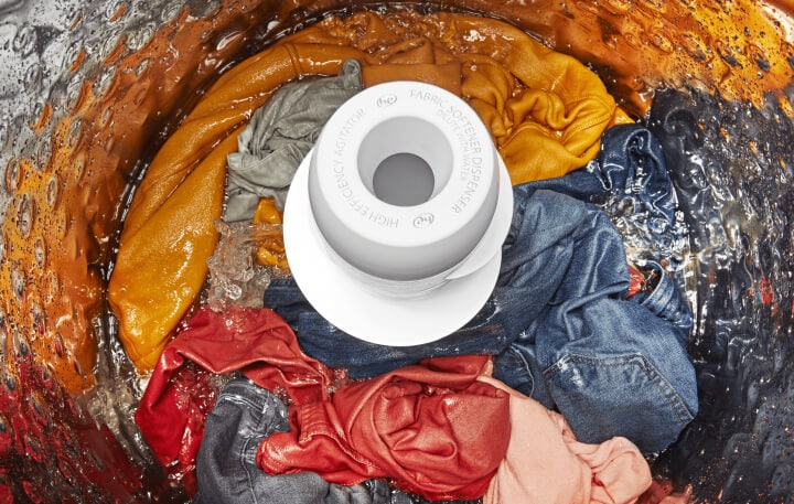 Wet clothing surrounding agitator in top-load washer drum. Wet clothing surrounding agitator in top-load washer drum.