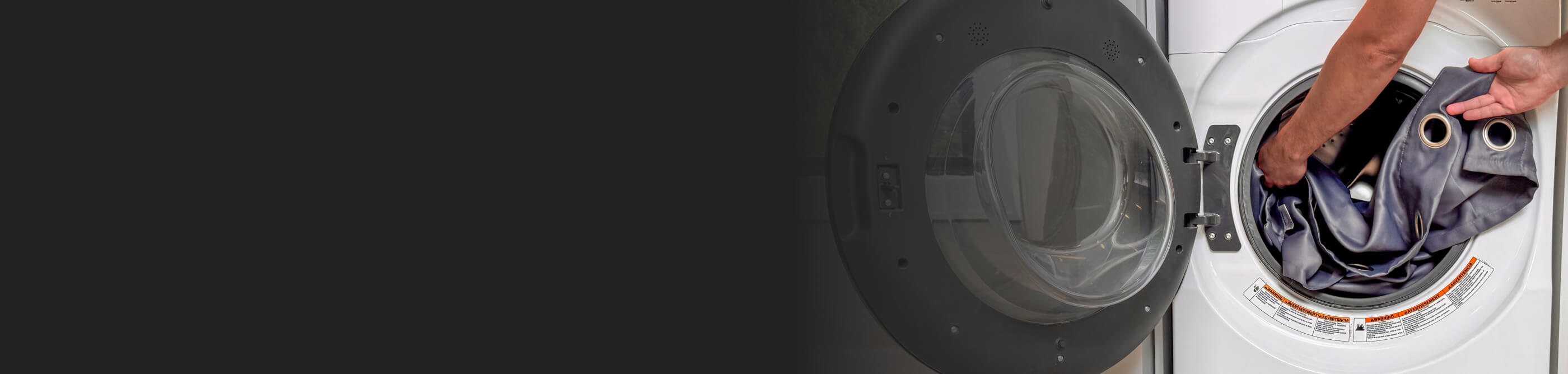 Someone putting curtains into a front load washer