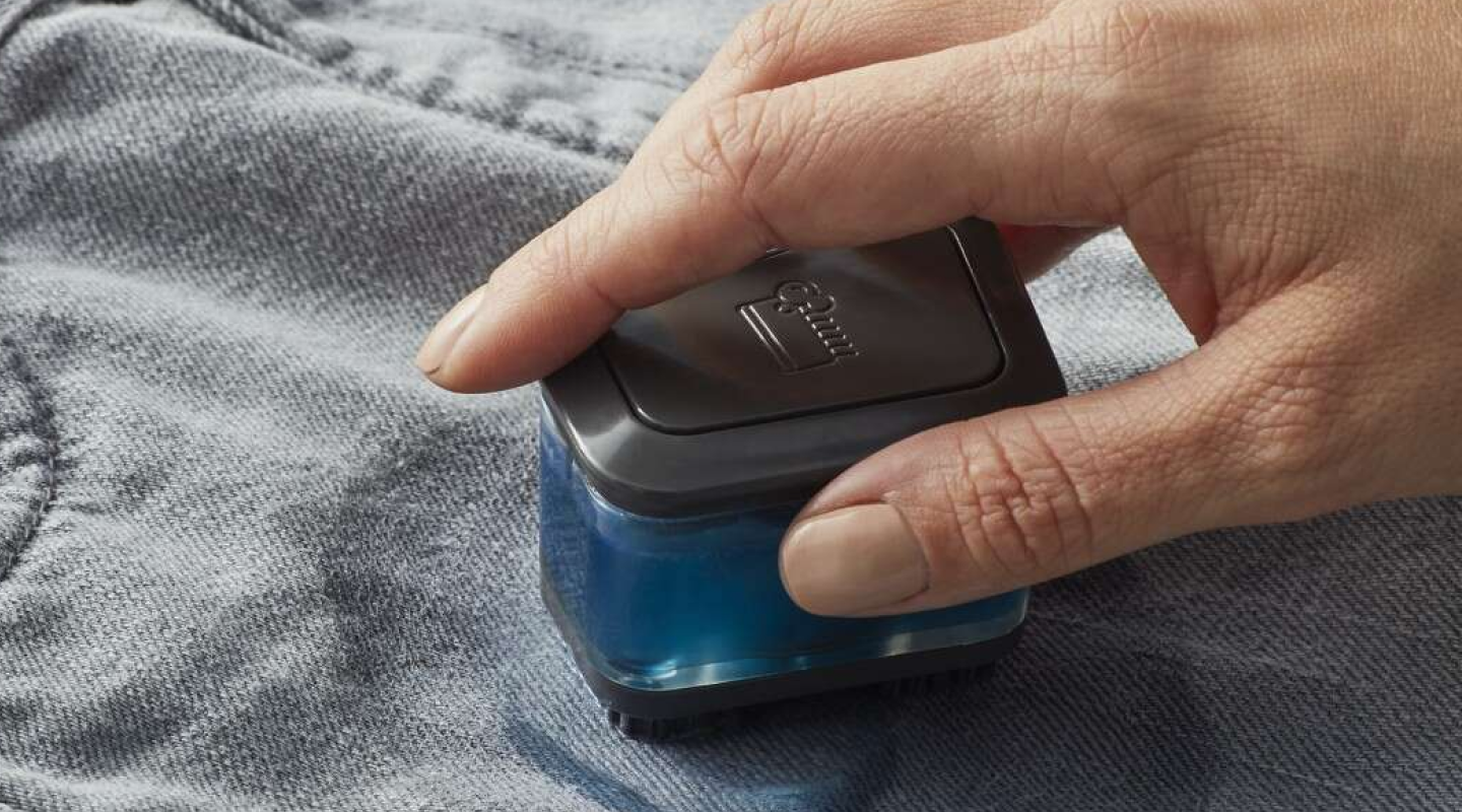 A closeup of a hand of a woman spot cleaning a garment.  A closeup of a hand of a woman spot cleaning a garment.