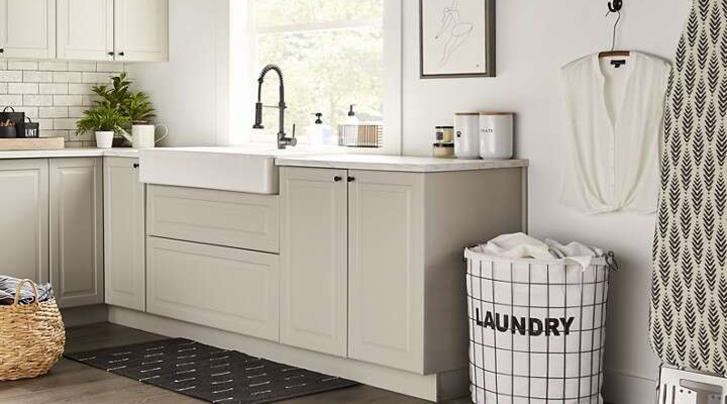 A laundry sink with beige cabinets in a modern laundry room. A laundry sink with beige cabinets in a modern laundry room.