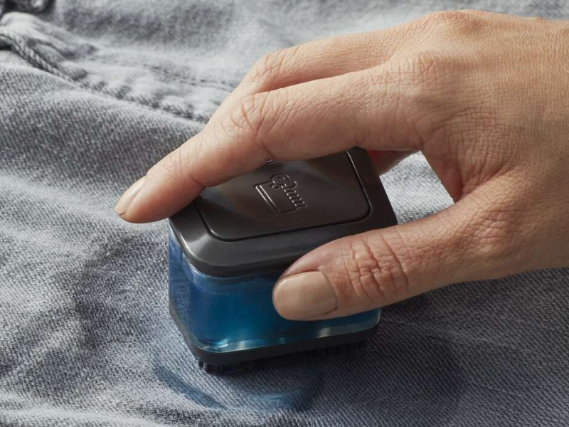 A closeup of a hand of a woman spot cleaning a garment.  A closeup of a hand of a woman spot cleaning a garment.