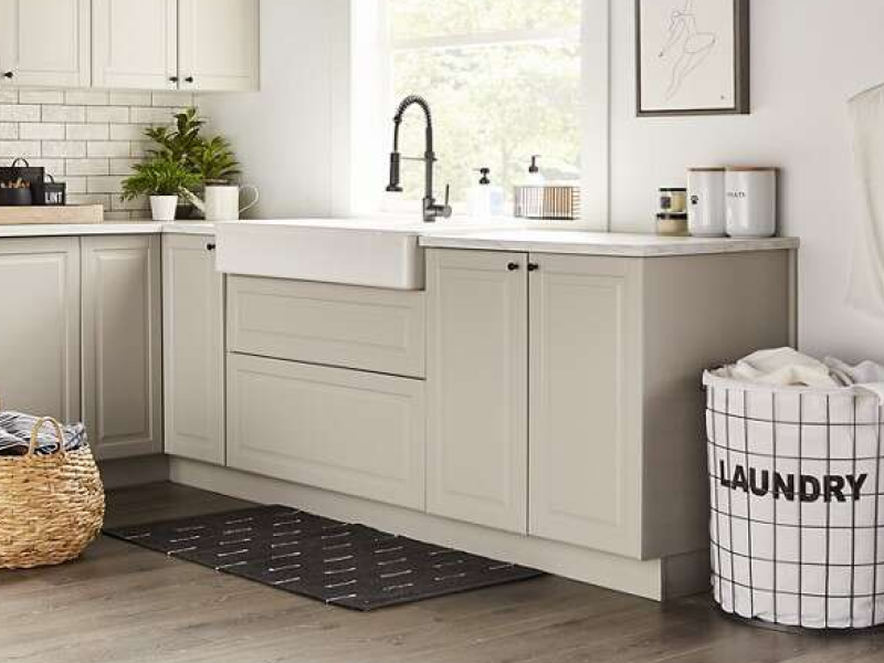 A laundry sink with beige cabinets in a modern laundry room. A laundry sink with beige cabinets in a modern laundry room.
