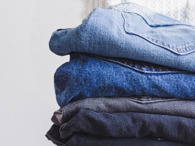 Four pairs of folded blue jeans Four pairs of folded blue jeans