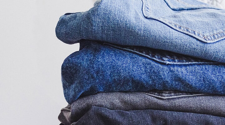 Four pairs of folded blue jeans Four pairs of folded blue jeans