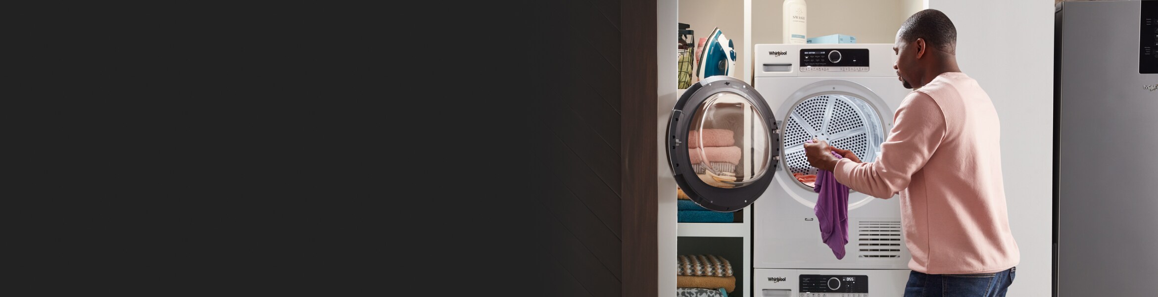 A man pulling a piece of clothing out of the dryer