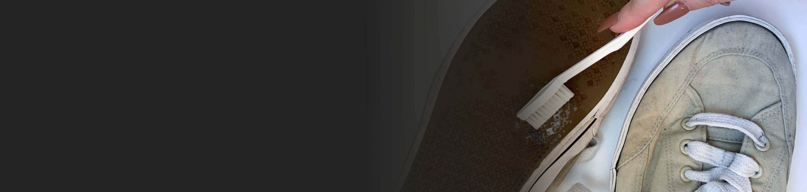 Person scrubbing the soles of a shoe with a toothbrush.