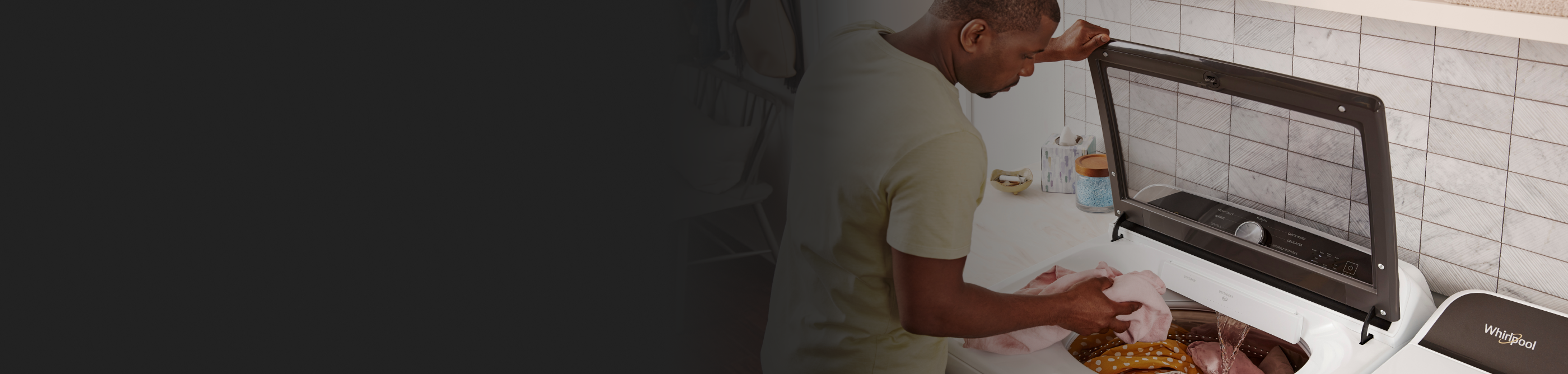 A man loading laundry into a top-load washer