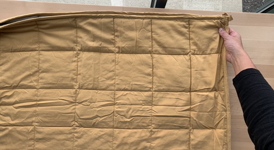 Person folding a weighted blanket  Person folding a weighted blanket