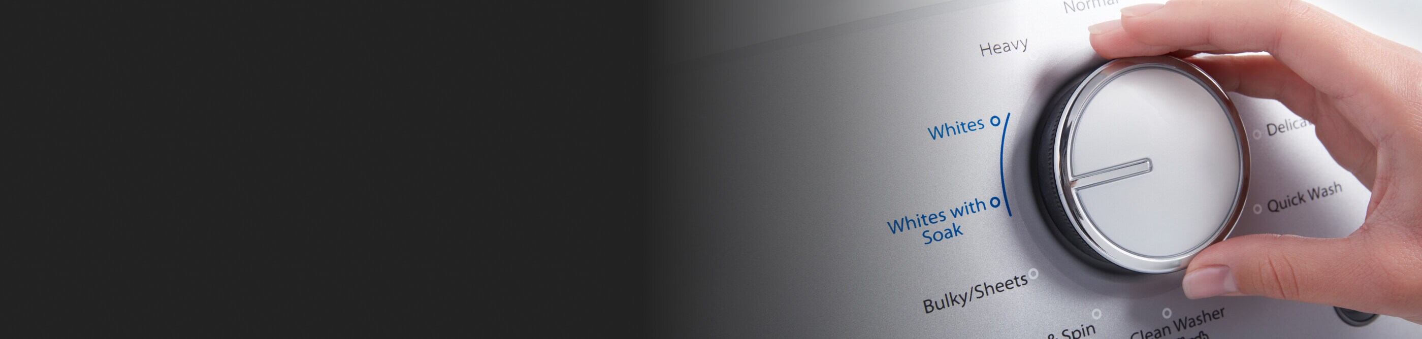 A hand on washing machine controls