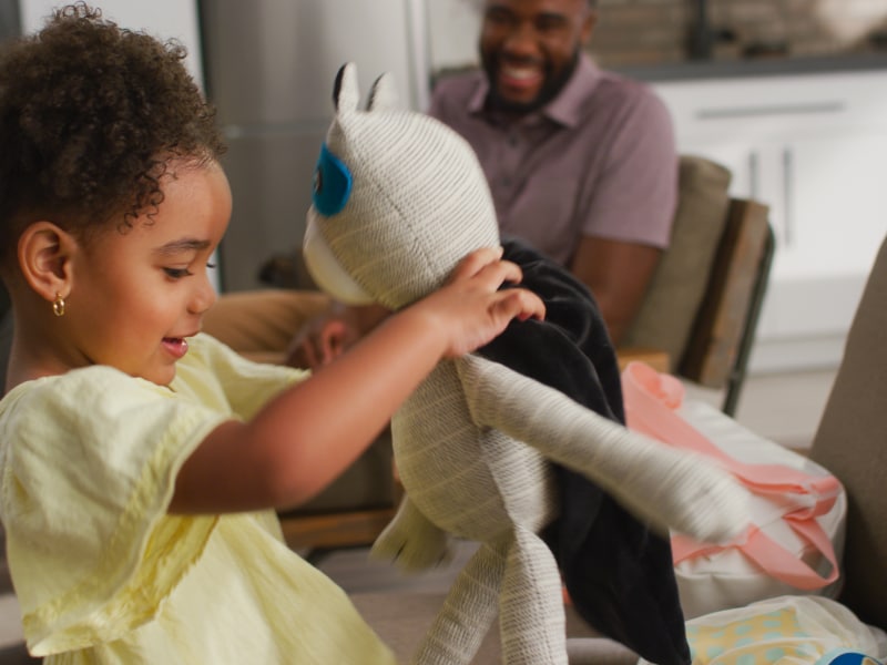 A young girl playing with a stuffed panda A young girl playing with a stuffed panda