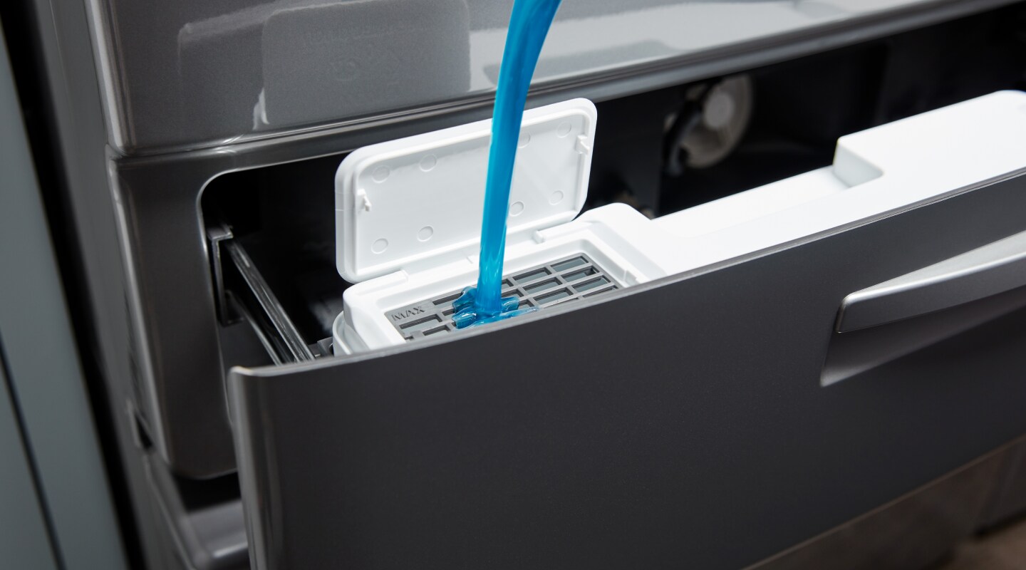 Detergent being loaded into a washer dispenser Detergent being loaded into a washer dispenser