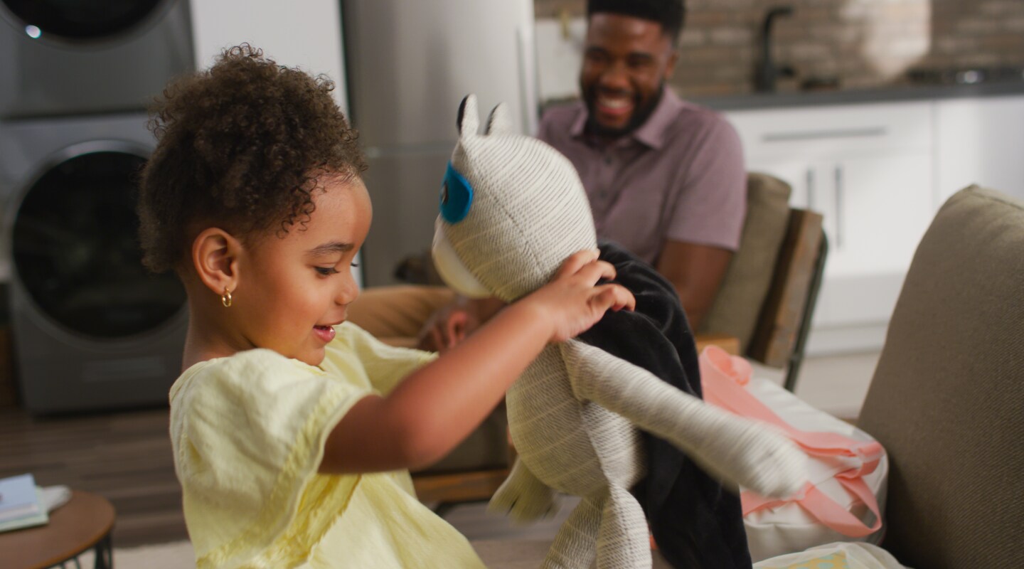 A young girl playing with a stuffed panda A young girl playing with a stuffed panda