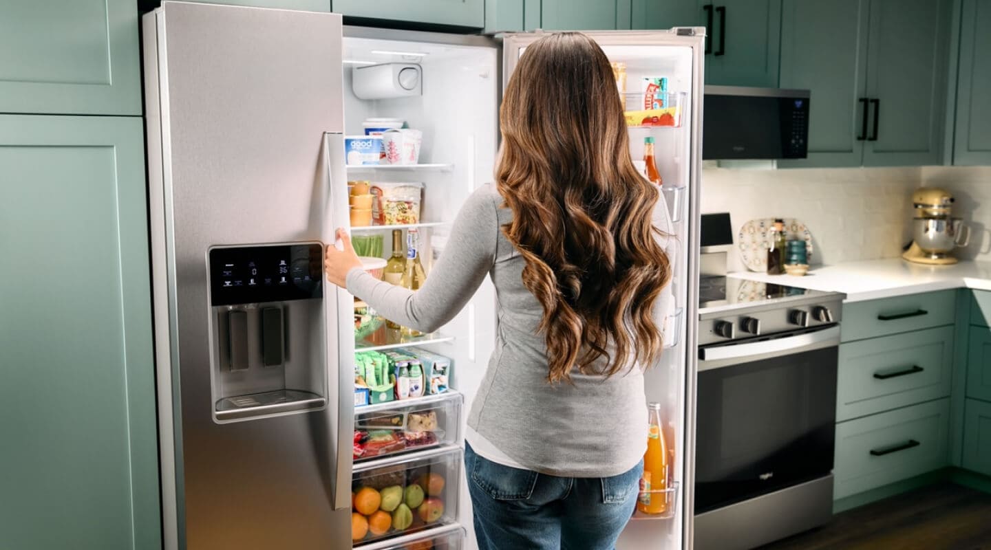 Person in front of a side-by-side refrigerator