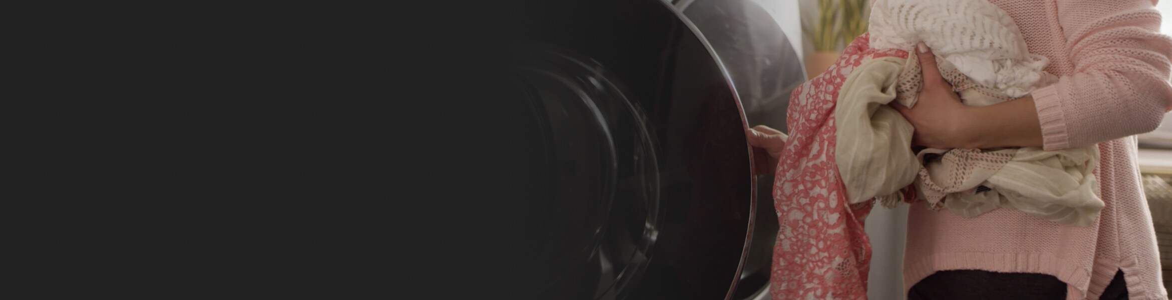 Woman loading clothes into high capacity front load washer