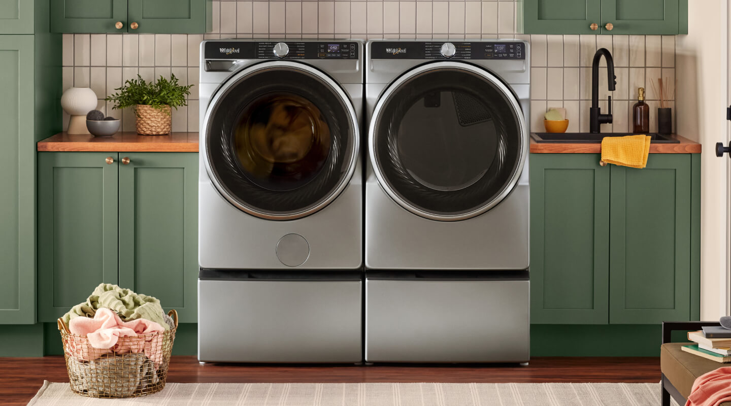Whirlpool® Front Load Washer and Dryer pair on pedestals in laundry room