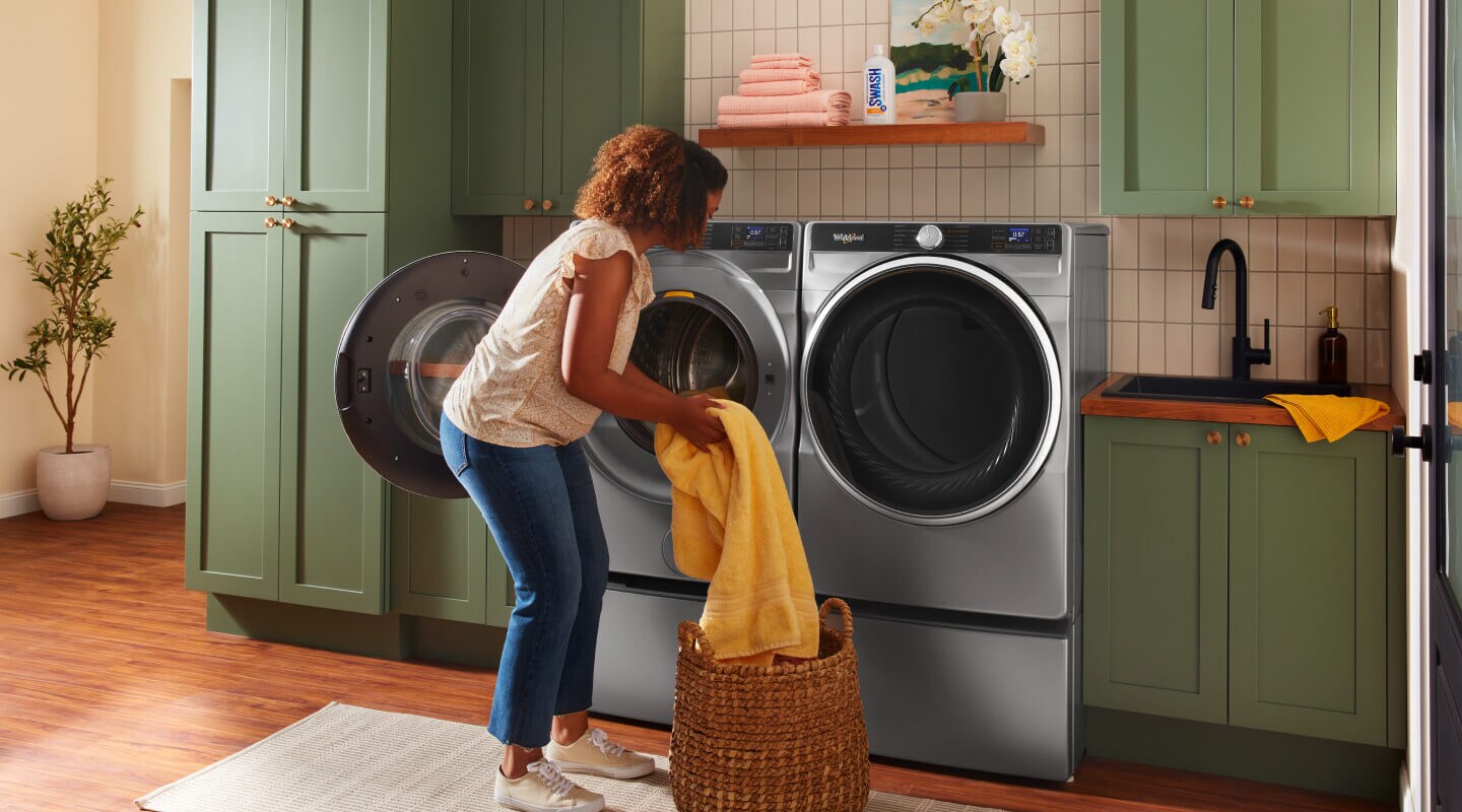 Person loading laundry into a Whirlpool® Front Load Washer